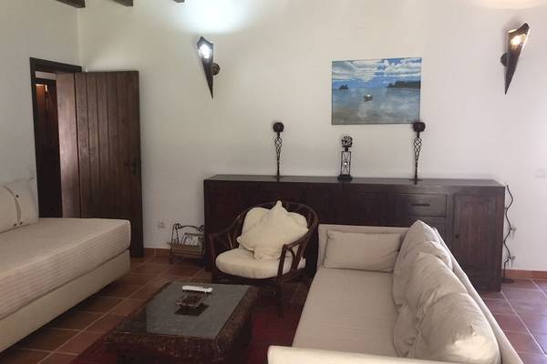 Wohnzimmer des Pedras da Rainha Resorts mit zwei Sofas, einem Tisch und einem Gemälde an der Wand.