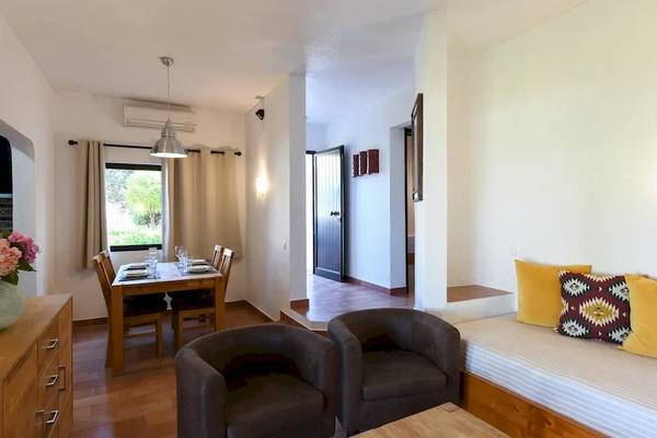 Wohnzimmer mit Tisch, Sofa und Blumenvase im Pedras da Rainha Resort