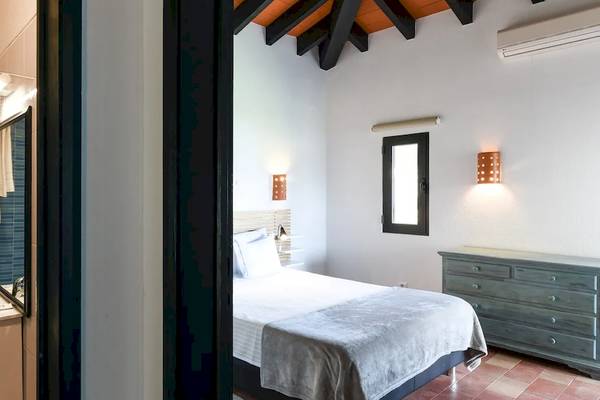 Hotelzimmer im Pedras da Rainha Resort mit Blick auf ein Badezimmer und ein Bett.