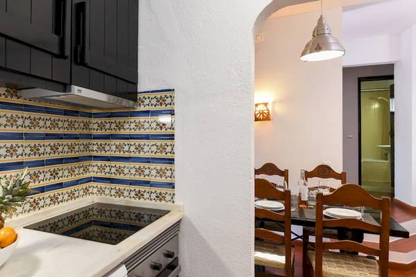 Küche im Pedras da Rainha Resort mit Obstschale, gefliester Wand und Esstisch
