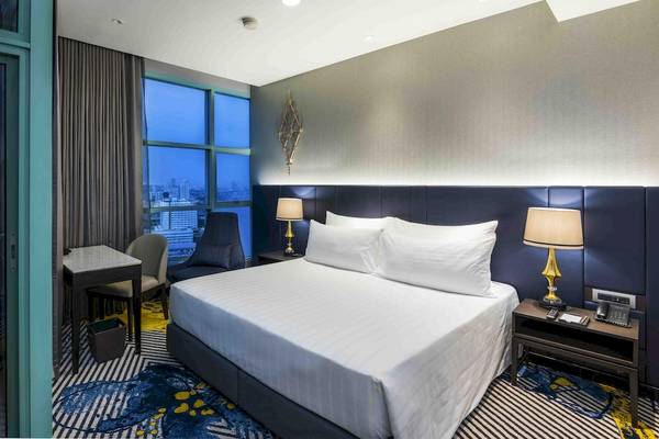 Zimmer im Chatrium Hotel Riverside Bangkok mit Blick auf die Stadt.