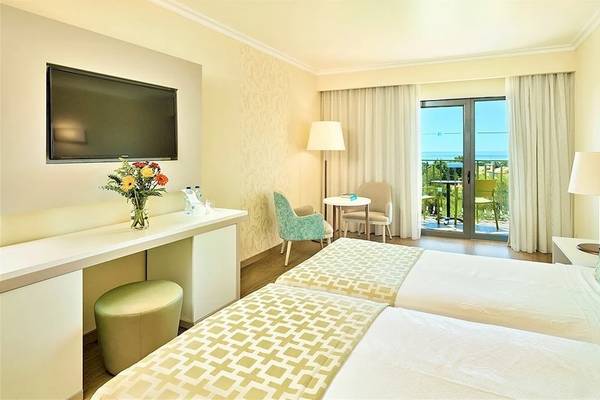 Doppelzimmer im Baia Grande Hotel mit Meerblick, zwei Betten, Fernseher, und Balkon.
