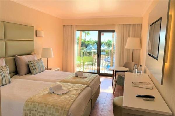 Doppelzimmer im Baia Grande Hotel mit Blick auf den Balkon und den Pool.