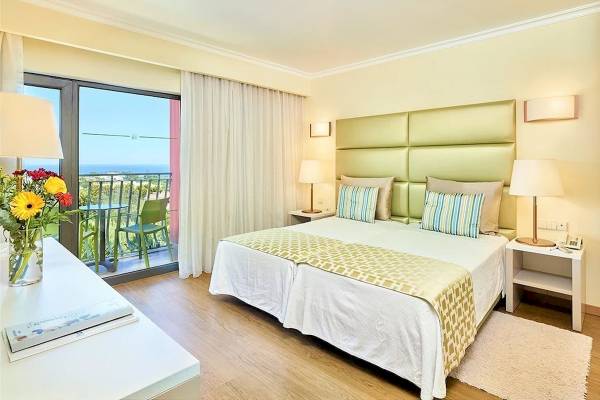 Ein Zimmer im Baia Grande Hotel mit Blick auf das Meer und einem Balkon.
