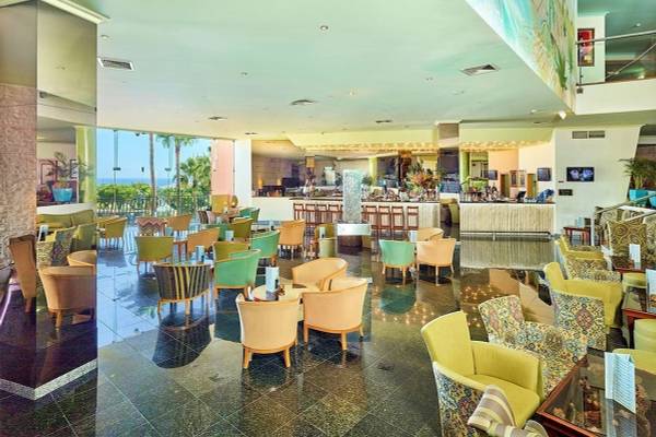 Loungebereich im Baia Grande Hotel mit farbenfrohen Stühlen und einer Theke.