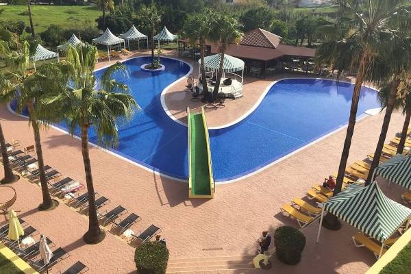 Luftaufnahme des Schwimmbadbereichs des Baia Grande Hotels mit Wasserrutsche und Sonnenliegen.