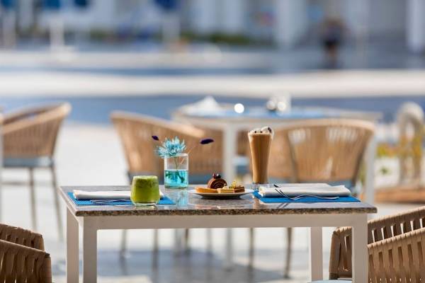 Außenbereich des Pickalbatros Blu Spa Resort mit einem Tisch, auf dem Getränke und Essen stehen.