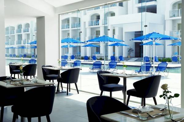 Innenansicht des Restaurants im Pickalbatros Blu Spa Resort mit Tischen und Stühlen.