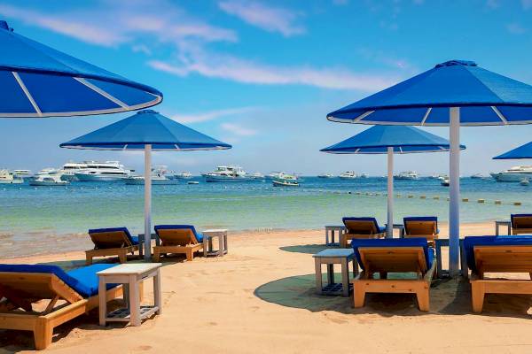Strand des Pickalbatros Blu Spa Resorts mit Sonnenliegen und Sonnenschirmen vor dem Hintergrund des Ozeans.