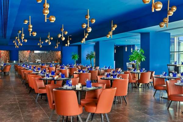 Restaurant des Pickalbatros Blu Spa Resorts mit orangen Stühlen und blauen Tischen