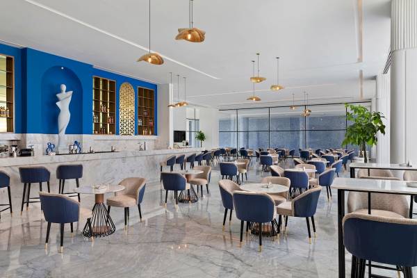 Innenraum des Pickalbatros Blu Spa Resorts mit blauen Wänden, Marmorboden und modernen Möbeln.