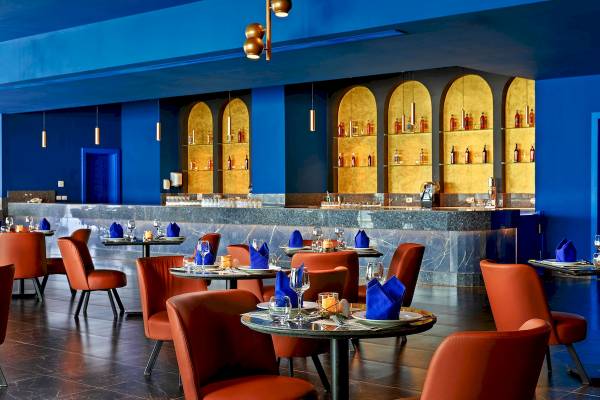 Hotelbar des Pickalbatros Blu Spa Resorts mit blauen Wänden und goldenen Details.