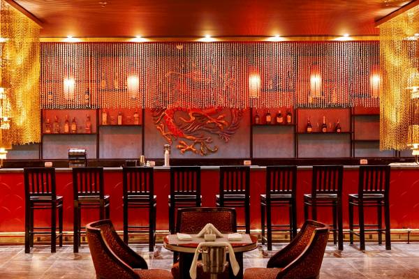 Innenansicht der Bar im Pickalbatros Blu Spa Resort mit roten Stühlen und Tisch.