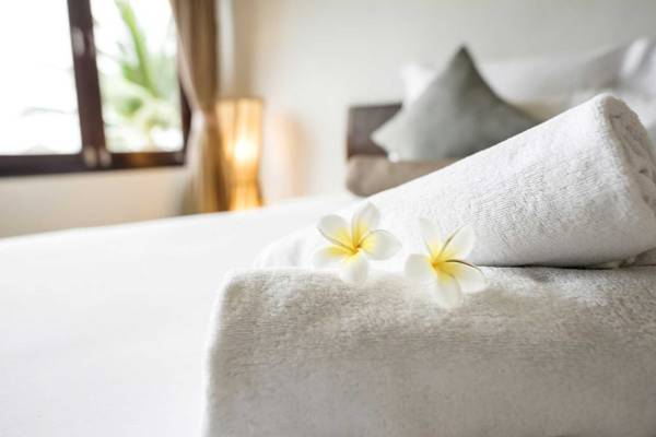 Bett im Amwaj Beach Club mit weißen Handtüchern und Blumen auf dem Bett