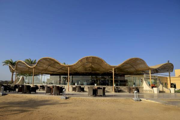 Außenterrasse des Amwaj Beach Club Hotels mit runden Tischen und Stühlen