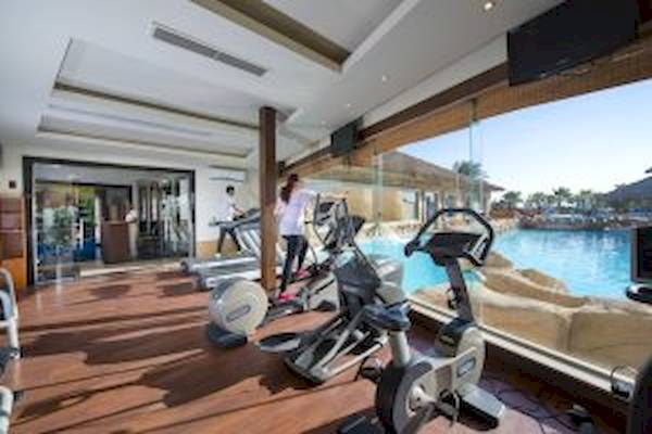 Fitnessbereich im Amwaj Beach Club mit Blick auf den Pool.