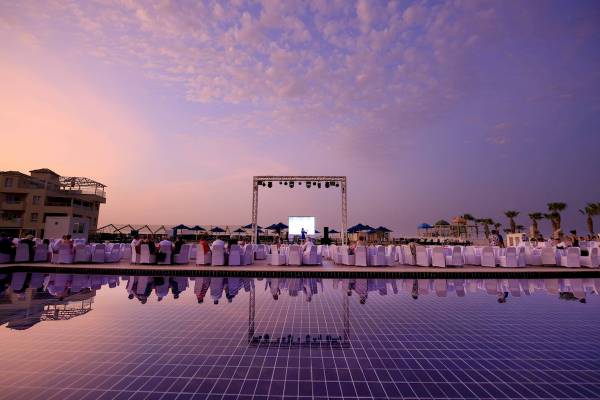 Amwaj Beach Club Abendveranstaltung im Pool-Bereich mit Gästen und Bühne.