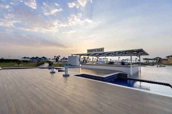 Terrasse des Amwaj Beach Club mit Pool und Bar bei Sonnenuntergang