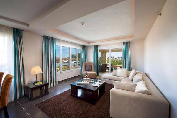 Wohnzimmer des Amwaj Beach Club mit großen Fenstern und Meerblick.