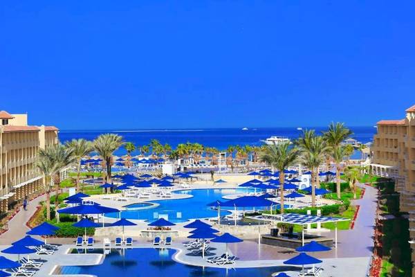 Luftaufnahme des Amwaj Beach Club Resorts mit großem Pool und vielen Liegestühlen und Sonnenschirmen.