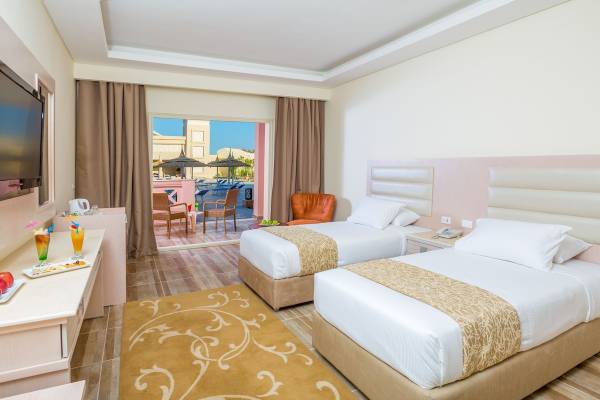 Doppelzimmer mit Balkon im Pickalbatros Aqua Vista Resort mit zwei Betten, einem Tisch und einem Fernseher.