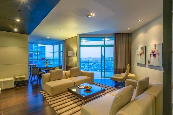 Wohnzimmer im Chatrium Hotel Riverside Bangkok mit Blick auf die Stadt.