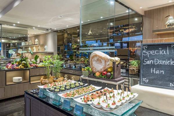 Buffet im Chatrium Hotel Riverside Bangkok mit verschiedenen Gerichten und einem großen schwarzen Brett.