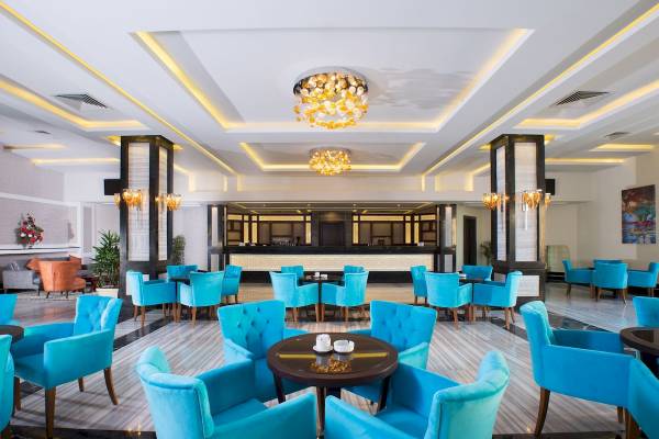 Lobby des Pickalbatros Aqua Vista Resorts mit blauen Stühlen und runden Tischen.