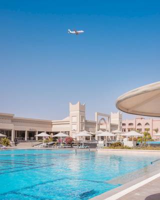 Das Pickalbatros Aqua Vista Resort zeigt einen Pool mit einem fliegenden Flugzeug.