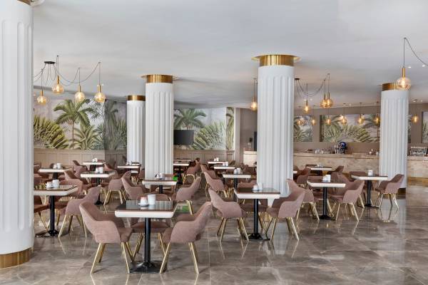 Innenansicht des Restaurants im Pickalbatros Water Valley Resort by Neverland mit runden Tischen, Stühlen und Säulen.