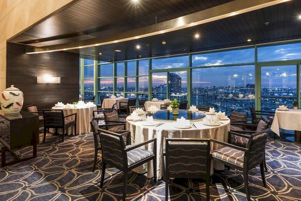 Chatrium Hotel Riverside Bangkok Innenbereich des Restaurants mit Blick auf die Stadt.