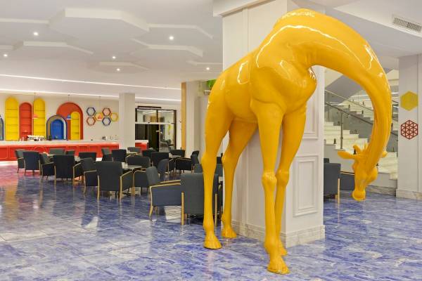 Foyer des Pickalbatros Water Valley Resort by Neverland mit gelber Giraffenstatue.