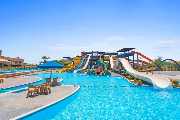 Wasserpark im Pickalbatros Water Valley Resort by Neverland mit mehreren Rutschen und Sonnenschirm.