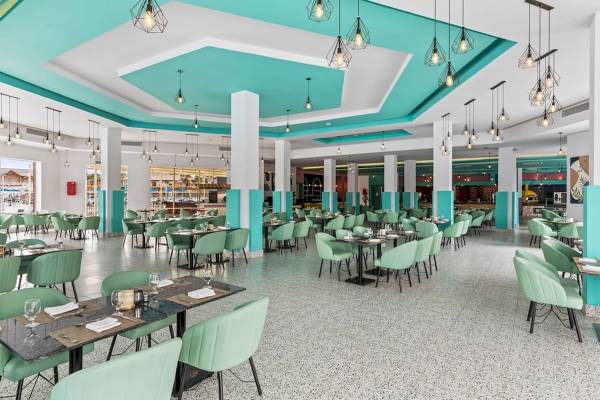 Innenraum des Restaurants im Pickalbatros Water Valley Resort by Neverland, mit blauen und weißen Wänden und grünen Stühlen.