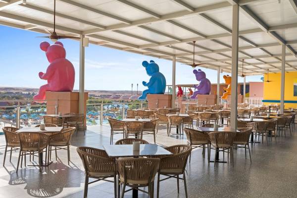Terrasse des Pickalbatros Water Valley Resorts mit bunten Bärenstatuen und Tischen.