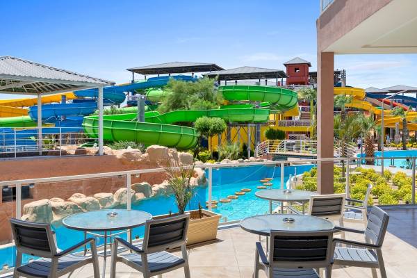 Außenbereich des Pickalbatros Water Valley Resorts mit Wasserrutschen und Tischen.