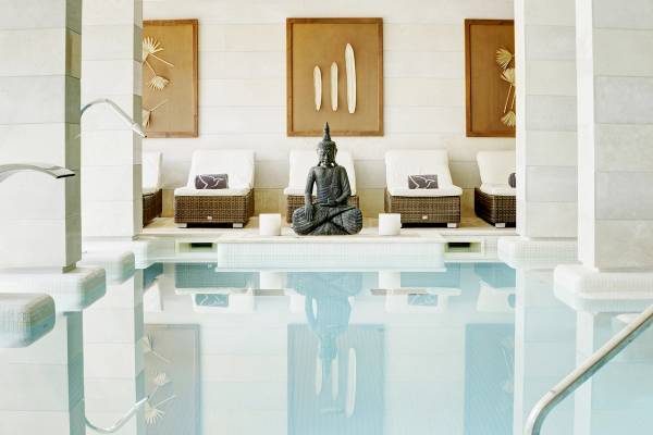 Innenpool des Grupotel Los Principes & Spa mit Buddha-Statue und Liegestühlen