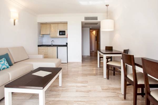 Innenraum des Grupotel Los Principes mit Wohnbereich, Sofa und Tisch.