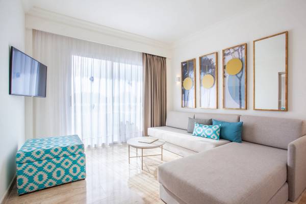 Wohnzimmer im Grupotel Los Principes & Spa mit Sofa, Tisch und Fernseher.