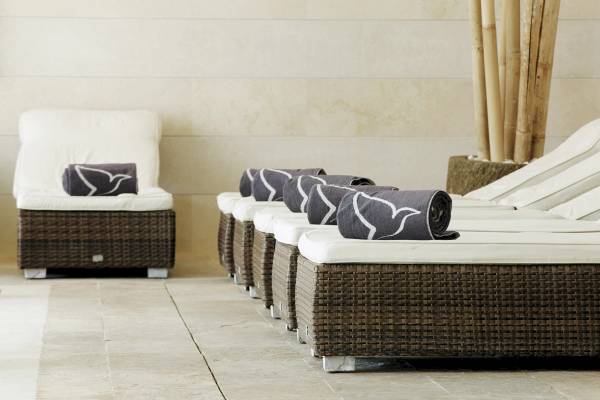 Gruppe von Rattansofas mit Handtüchern auf dem Grupotel Los Principes & Spa.