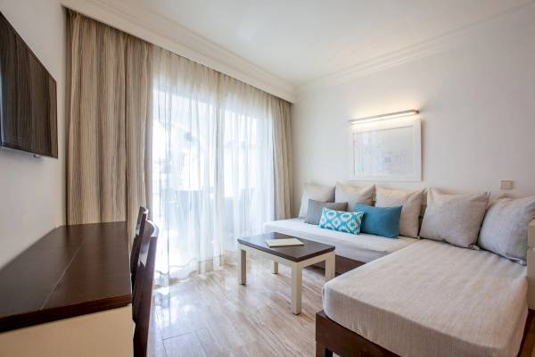 Gruppetel Los Principes & Spa Innenraum mit Sofa, Tisch und Fernseher