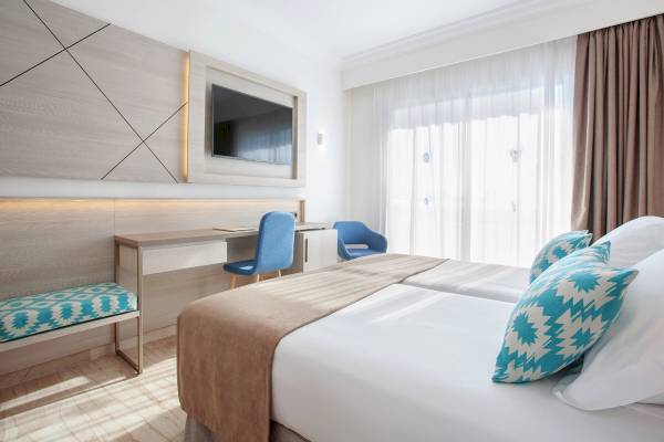 Doppelzimmer im Grupotel Los Principes mit zwei Betten, Schreibtisch und Fernseher.