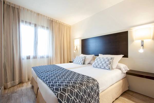 Doppelbettzimmer im Grupotel Los Principes & Spa Hotel mit modernen Möbeln und stilvoller Einrichtung.