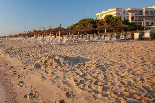 Gruppenhotel Los Principes & Spa Strand mit Sonnenliegen und Sonnenschirmen