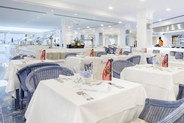 Innenansicht des Restaurants des Grupotel Los Principes & Spa mit gedeckten Tischen und Stühlen.