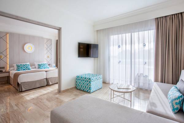 Doppelzimmer im Grupotel Los Principes & Spa Hotel mit zwei Betten, Fernseher und Fenstern.