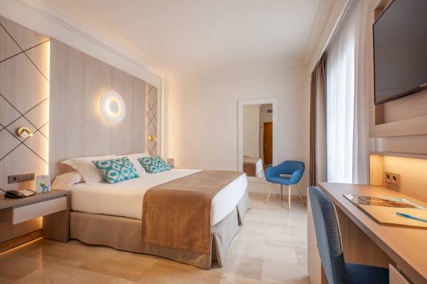 Gruppetel Los Principes Hotelzimmer mit Bett, Schreibtisch und Fernseher