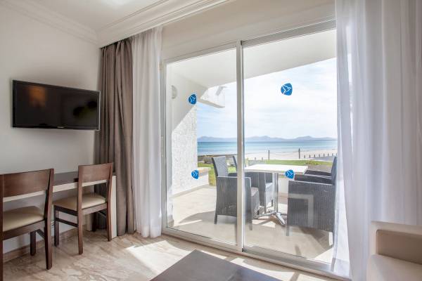 Innenansicht eines Zimmers im Grupotel Los Principes & Spa mit Blick auf eine Terrasse und einen Ozean.