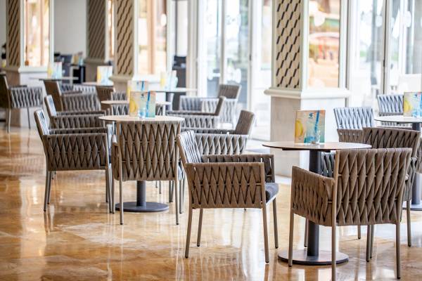 Innenbereich des Grupotel Los Principes & Spa Hotels mit vielen Stühlen und Tischen.