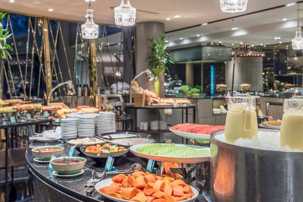Frühstücksbuffet im Chatrium Hotel Riverside Bangkok mit verschiedenen Gerichten und Früchten.